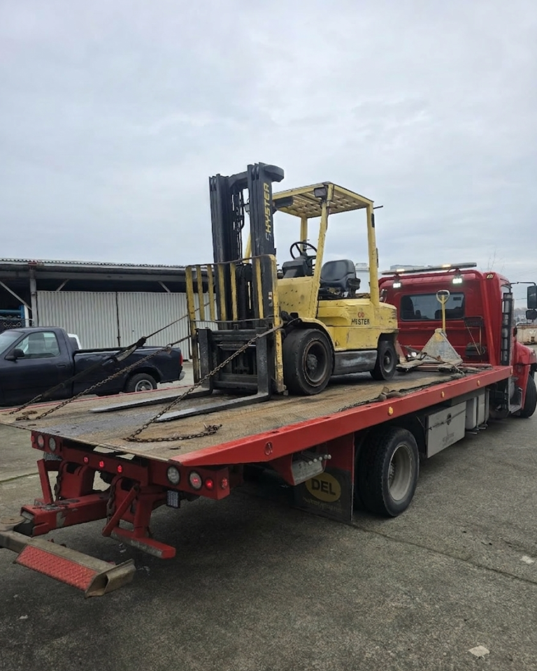 Red Tow Truck carrying scrap forklift in surrey